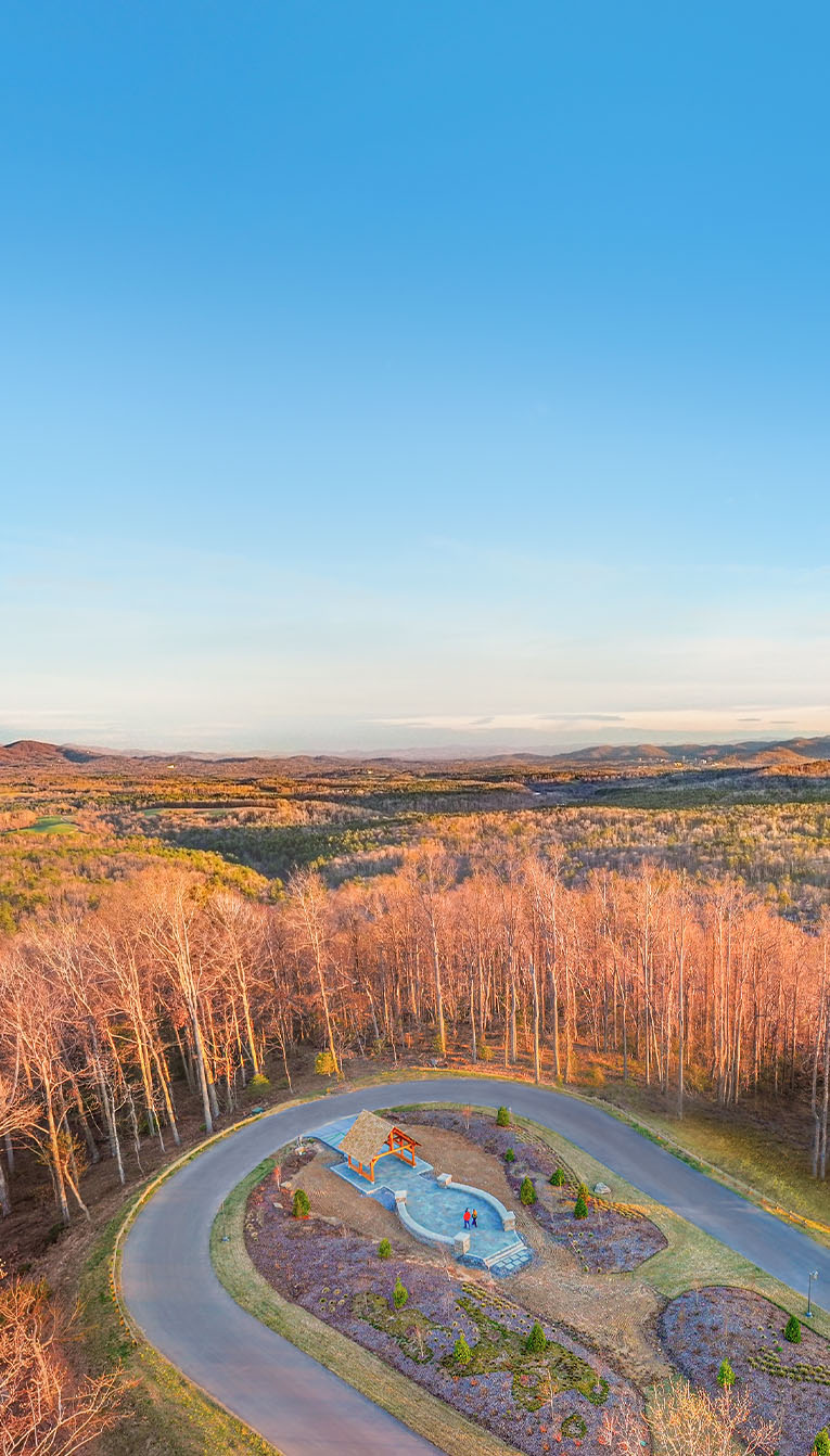 Mountain, blue sky, and small building with a road.